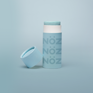 A single blue Nöz sunscreen stick in front of a blue background.